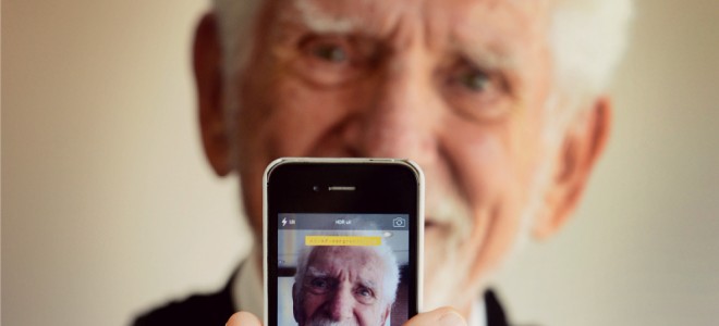 Martin Cooper sosteniendo smartphone con su foto