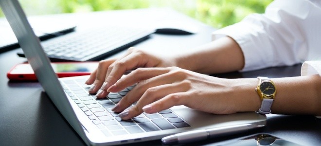 Manos de mujer escribiendo en laptop